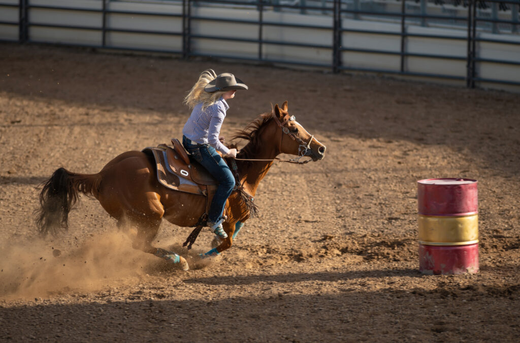 Cowgirl barrel racing at a local rodeo arena