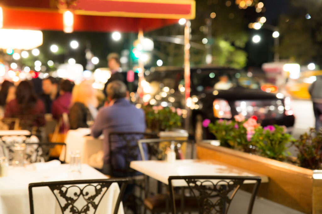Defocused blur of outdoor restaurant scene with non recognizable diners at night